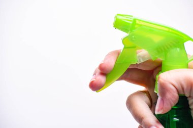 Plastik sprey şişesini tut. Plastik sprey şişeyi beyaza yalıtılmış tut. Elinde su püskürtücüsü olan bir adam..