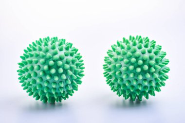 İki yeşil renkli, parlak, izole edilmiş dikenli top oyuncağı, makro.
