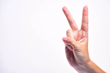 Kızın eli zafer eli gösteriyor. Zaferin sembolü. El, beyaz arka planda izole edilmiş. Boşluğu kopyala