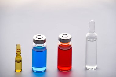 İğne için ilaç şişeleri ve ampuller. İlaçlar ve hastalık tedavisi. Mavi ve kırmızı tüpler ve ampuller. Farmakoloji ve bilim. Boşluğu kopyala.