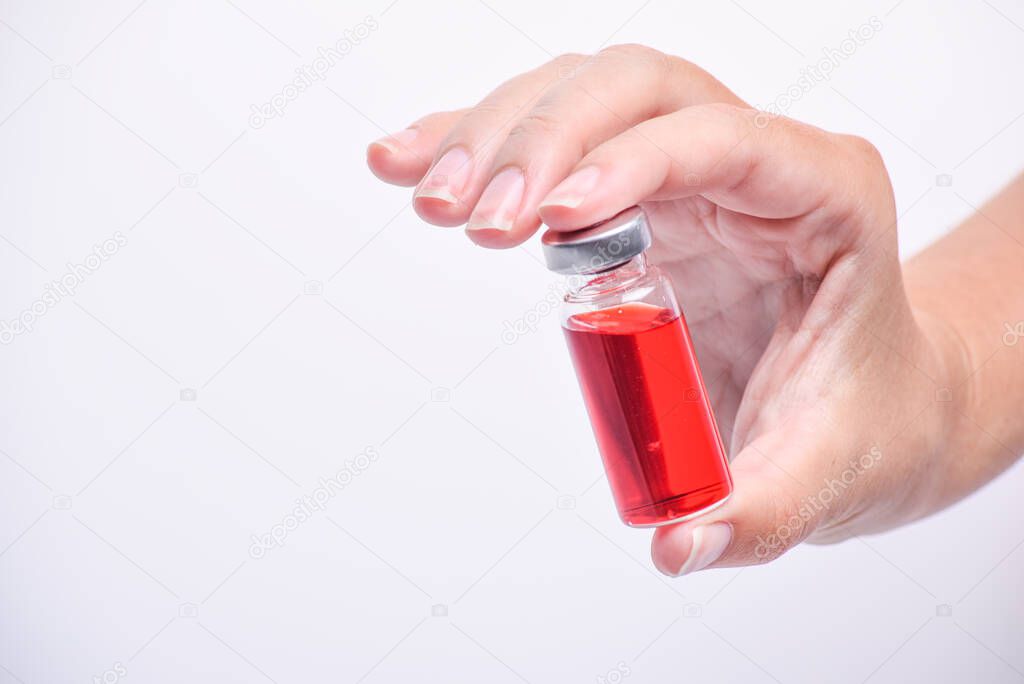 A woman's hand holds an medical vial or ampoule. Vaccine. The ampoule with the medicine. Medication for injection.