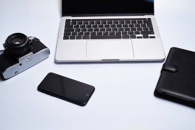 Beyaz bir arka planda fotoğrafçının işyeri. Modern laptop, dijital kamera, lens, pil, akıllı telefon. Minimalizm. Üst Manzara. Uzayı kopyala Fotoğrafçı için ekipman. Bağımsız çalışma kavramı.