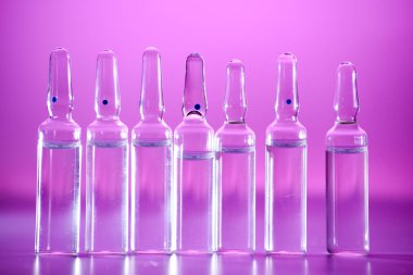 Beyaz arka planda arka arkaya birçok tıbbi ampul. Yakın plan.