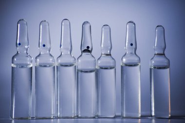 Beyaz arka planda arka arkaya birçok tıbbi ampul. Yakın plan.