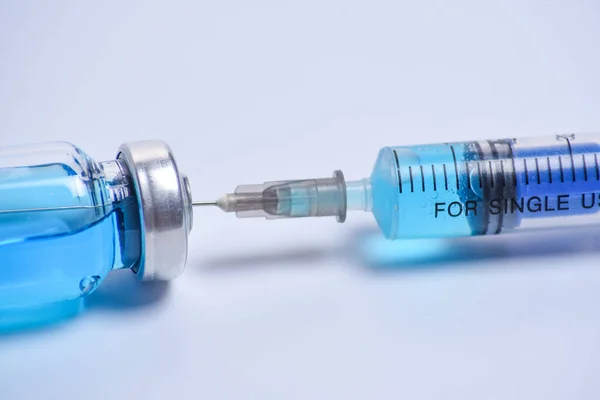 Jeringa Médica Vacuna Vial Azul Sobre Fondo Blanco Con Enfoque —  Fotos de Stock