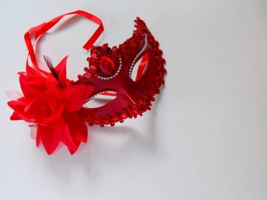 Işık arka planında kırmızı karnaval maskesi. Yeni Yıl ve Caranaval konsepti