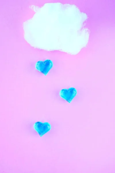 Cloud with heart rain on a pastel pink background. Creative idea. Minimum concept for a banner