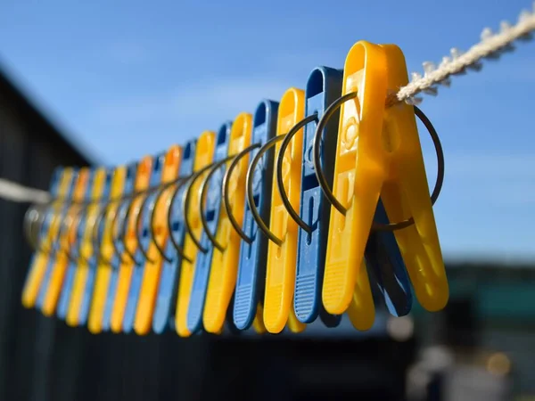 Blue Yellow Clothespins Rope Hangs Street Blue Sky Green Foliage — Stock Photo, Image