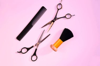 Pembe arka planda çeşitli aksesuarları kuaförlemek. Kuaför güzellik endüstrisi konsepti. kuaför makası ve tarak