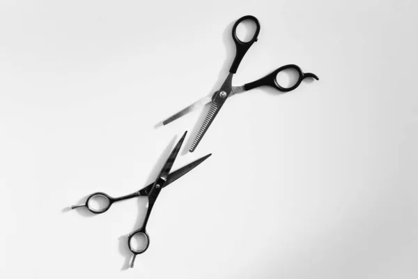 pair of hairdressing scissors on a light background close up