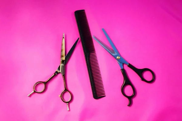 用粉红的背景做各种配饰 美发行业的概念 理发剪刀和梳子 — 图库照片