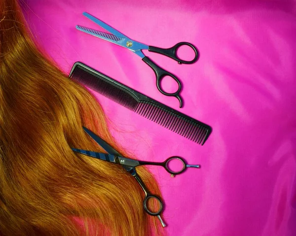 long loose hair and a hairdressing set on a pink background. the concept of the beauty industry hairdresser