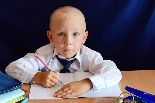 Çocuk masaya oturur ve dersler öğrenir. Yakında okula gideceğim..
