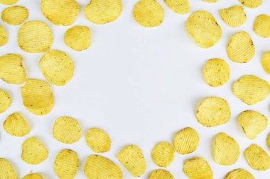 Patates cipsi arka planda tepeden bakıldığında hafif görünüyor. Zararlı beslenme kavramı, kopyalama alanı 