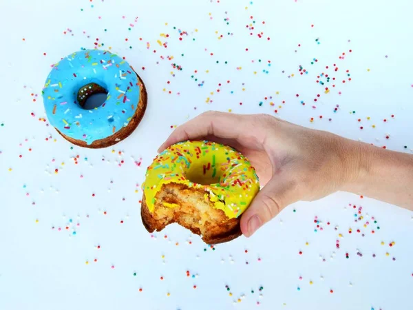 Kadının eli arka planda nefis bir donut tutuyor, yakın plan.