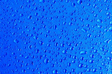 Mavi arkaplandaki bir su damlasının soyut görüntüsü. Kartpostal veya afiş arkaplanı için su damlası yapısı kavramı