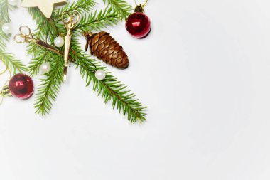 Noel kompozisyonu kuaför aletleri, kırmızı Noel topları ve arka planda koni olan bir köknar dalı. Boşluğu kopyala.