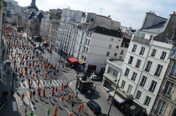 İnsanlar Paris sokaklarında koşuyor.