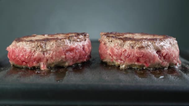 Close-up hambúrgueres de carne angus estão cozinhando na grelha, hambúrgueres de carne rara, 4K — Vídeo de Stock