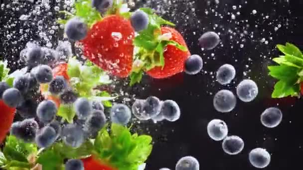 Świeże jagody wpadają do wody. Truskawki, jagody rozpryski w wodzie — Wideo stockowe