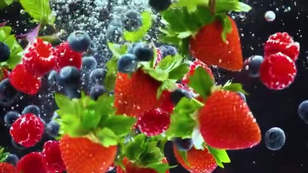 草莓，蓝莓，覆盆子，薄荷飞溅在水里，特写 — 图库视频影像