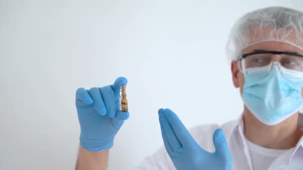 El médico explica cómo usar las vacunas y sostiene las ampollas en las manos, copia el espacio — Vídeo de stock