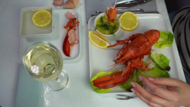 Homar na talerzu, kobieta jedząca mięso homara zanurzająca się w sosie, widok z góry, 4K — Wideo stockowe