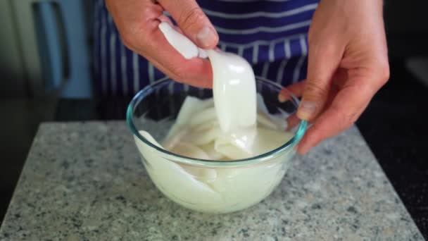 Canales de calamar, un chef mezcla con la mano los calamares crudos en un recipiente de vidrio, primer plano — Vídeos de Stock