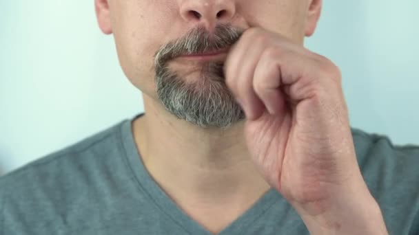 Um homem de meia idade limpa o bigode depois de comer com a mão, close-up, 4K — Vídeo de Stock