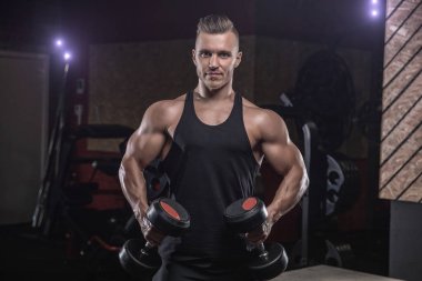 Çekici uzun kaslı vücut geliştirici. Moder fitness merkezinde ağırlık kaldırıyor..