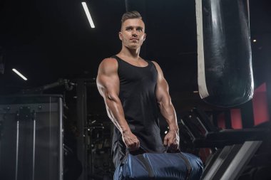 Çekici uzun kaslı vücut geliştirici. Moder fitness merkezinde ağırlık kaldırıyor..