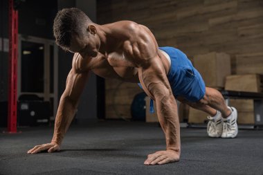 Yakışıklı adam spor salonunda egzersiz kamera önünde poz