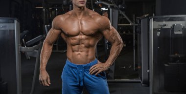 Yakışıklı adam spor salonunda egzersiz kamera önünde poz