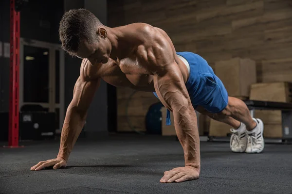 Yakışıklı adam spor salonunda egzersiz kamera önünde poz
