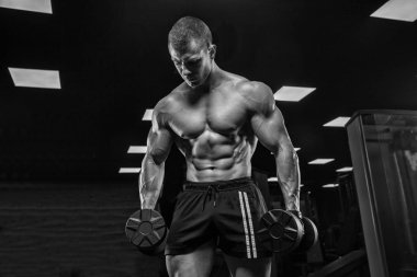 Bir adam pazı, halter ile eğitim salonunda, trenler.