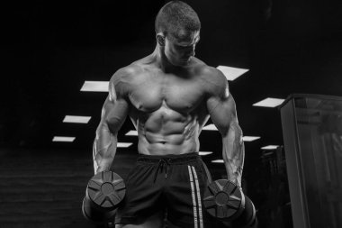 Bir adam pazı, halter ile eğitim salonunda, trenler.