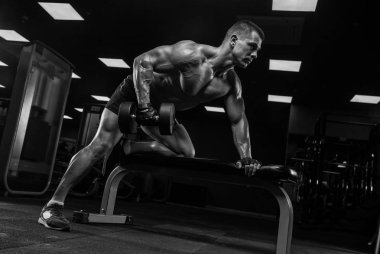 Bir adam pazı, halter ile eğitim salonunda, trenler.