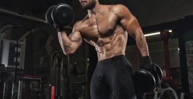 Kaslı atletik vücut fitness model spor salonunda egzersiz sonra poz