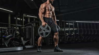 Çekici uzun kaslı vücut geliştirici. Moder fitness merkezinde ağırlık kaldırıyor..