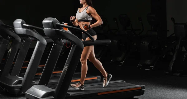 Pretty Latin young women working out in an elliptical trainer in — Stock Photo, Image