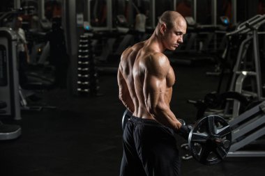 Dambıl ile egzersiz kas delikanlı. Adam onun pazı trenler