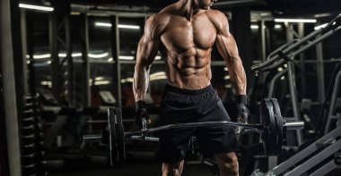 Spor salonunda eğitim ve kas poz kaslı adam vücut geliştirmeci