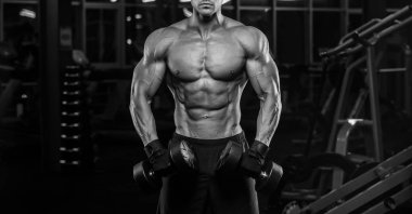 Dambıl ile egzersiz kas delikanlı. Adam onun pazı trenler