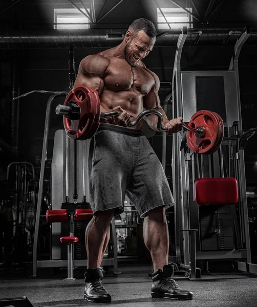 Brutal fuerte atlético hombres bombeando los músculos y entrenar en el gimnasio w — Foto de Stock