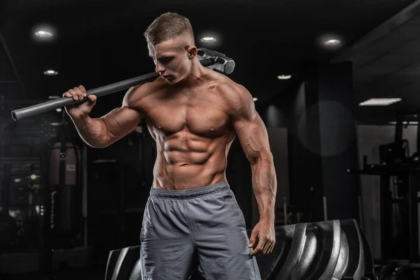 Jonge mannelijke atleet bodybuilder poseren en doen sportoefeningen — Stockfoto