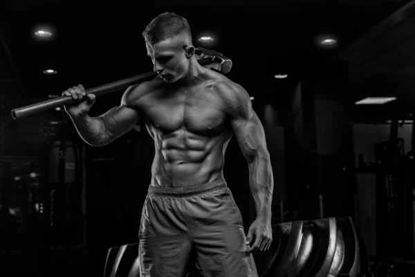 Unga manliga atlet bodybuilder poserar och gör idrotts övningar — Stockfoto