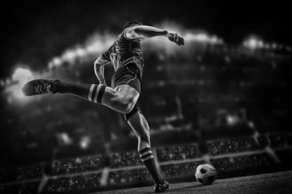 Футболист с мячом на поле стадиона — стоковое фото