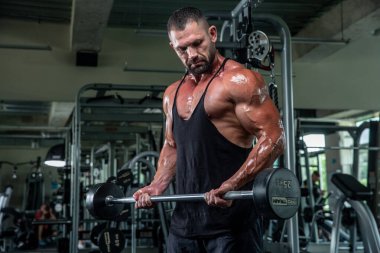 Çekici uzun kaslı vücut geliştirici. Moder fitness merkezinde ağırlık kaldırıyor..