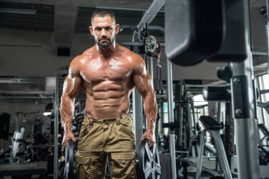 Çekici uzun kaslı vücut geliştirici. Moder fitness merkezinde ağırlık kaldırıyor..