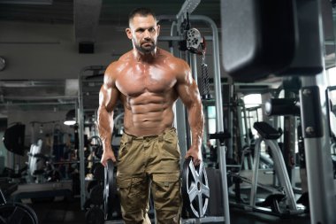 Çekici uzun kaslı vücut geliştirici. Moder fitness merkezinde ağırlık kaldırıyor..